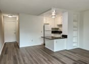 Thumbnail 13 of 22 - an empty living room with a kitchen in the background