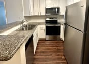 Thumbnail 9 of 29 - a kitchen with granite counter tops and stainless steel appliances