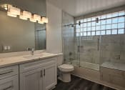 Thumbnail 31 of 52 - a bathroom with a shower and a sink and a toilet