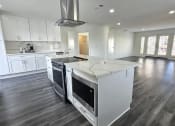 Thumbnail 48 of 52 - a kitchen with white cabinets and a large island with a stove and a microwave