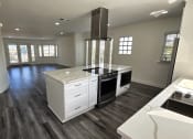 Thumbnail 32 of 52 - a kitchen with a center island and a stove and a living room