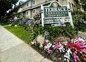 Thumbnail 29 of 29 - A sign for Terrace Apartments is in front of a building.