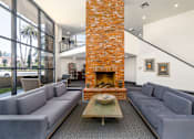Thumbnail 4 of 22 - a living room with couches and a large brick fireplace