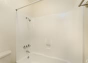 Thumbnail 19 of 22 - a white bathroom with a shower and a toilet