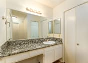 Thumbnail 17 of 22 - a bathroom with a granite counter top and a large mirror