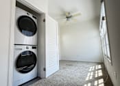 Thumbnail 31 of 60 - A white washer and dryer in a laundry room with a ceiling fan.