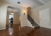 Thumbnail 33 of 60 - A spacious room with a staircase leading to the second floor.
