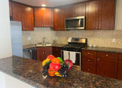 Thumbnail 5 of 30 - a kitchen with wooden cabinets and granite countertops