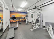 Thumbnail 30 of 30 - A gym with a treadmill, weights, and exercise equipment.