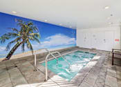 Thumbnail 29 of 30 - A wall mural of a beach scene is behind a small indoor pool.