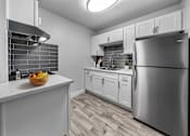 Thumbnail 7 of 25 - A kitchen with a refrigerator, sink, and cabinets.