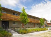 Thumbnail 5 of 11 - a building with a wooden balcony and a grassy area in front of it