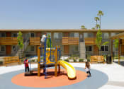 Thumbnail 7 of 11 - a playground with a slide and climbers in front of a building