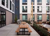 Thumbnail 3 of 17 - a communal area with benches in front of an apartment building