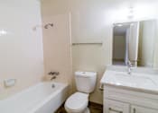 Thumbnail 15 of 15 - A white bathroom with a toilet, sink, and bathtub.