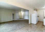 Thumbnail 14 of 15 - A kitchen area with a refrigerator, sink, and cabinets.