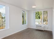 Thumbnail 14 of 17 - an empty living room with large windows and a radiator