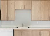 Thumbnail 12 of 17 - a kitchen with wooden cabinets and a sink