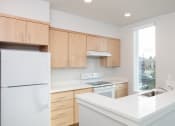 Thumbnail 10 of 17 - an empty kitchen with white counter tops and wooden cabinets