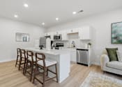 Thumbnail 1 of 25 - A kitchen with white cabinets and a white island with brown chairs.