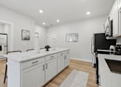 Thumbnail 2 of 25 - A modern kitchen with white cabinets and a marble countertop.