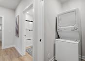Thumbnail 6 of 25 - A white washing machine in a laundry room.