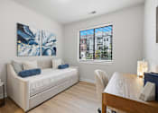 Thumbnail 10 of 25 - A living room with a white couch and a painting on the wall.