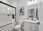 Thumbnail 24 of 25 - A bathroom with a toilet, sink, and mirror.