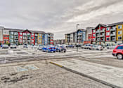 Thumbnail 22 of 72 - A parking lot with cars and apartment buildings in the background.