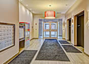 Thumbnail 68 of 72 - A hallway with a red chandelier and a black door.