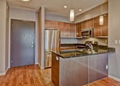 Thumbnail 66 of 72 - A kitchen with a refrigerator, microwave, and sink.
