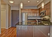 Thumbnail 65 of 72 - A kitchen with a granite counter top and stainless steel appliances.