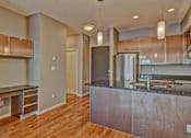 Thumbnail 64 of 72 - A kitchen with a stainless steel island and wooden floors.