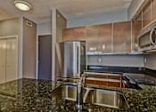 Thumbnail 63 of 72 - A kitchen with a granite counter top and stainless steel appliances.