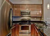 Thumbnail 61 of 72 - A modern kitchen with a stainless steel refrigerator and wooden cabinets.