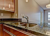 Thumbnail 59 of 72 - A modern kitchen with a granite countertop and stainless steel sink.