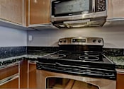 Thumbnail 58 of 72 - A black stove top oven with a digital display in the middle.