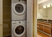 Thumbnail 52 of 72 - A white front loading washing machine in a laundry room.