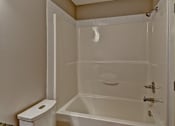 Thumbnail 50 of 72 - A white bathroom with a toilet, tub, and shower.