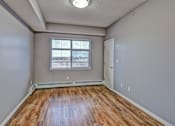 Thumbnail 47 of 72 - A room with a window and wooden flooring.