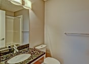 Thumbnail 46 of 72 - A bathroom with a sink, toilet, and a mirror.