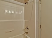 Thumbnail 45 of 72 - A white bathroom with a shower and a door.