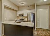 Thumbnail 40 of 72 - A kitchen with a refrigerator, microwave, and oven.