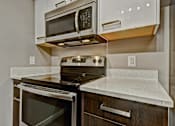 Thumbnail 37 of 72 - A modern kitchen with a microwave oven mounted above a stove.