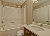 Thumbnail 27 of 72 - A white bathroom with a toilet, sink, and bathtub.