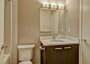 Thumbnail 26 of 72 - A bathroom with a white toilet, sink, and mirror.