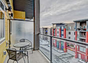 Thumbnail 24 of 72 - A balcony with a table and chairs overlooks a snowy street.