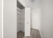 Thumbnail 19 of 33 - an empty closet in a room with white walls and wood floors