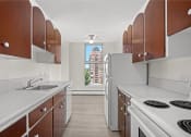 Thumbnail 13 of 33 - a kitchen with white appliances and wooden cabinets and a window