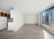 Thumbnail 15 of 33 - a spacious living room with large windows and a kitchen